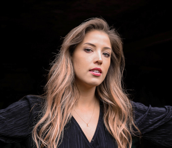 A striking woman, crowned in onyx waves